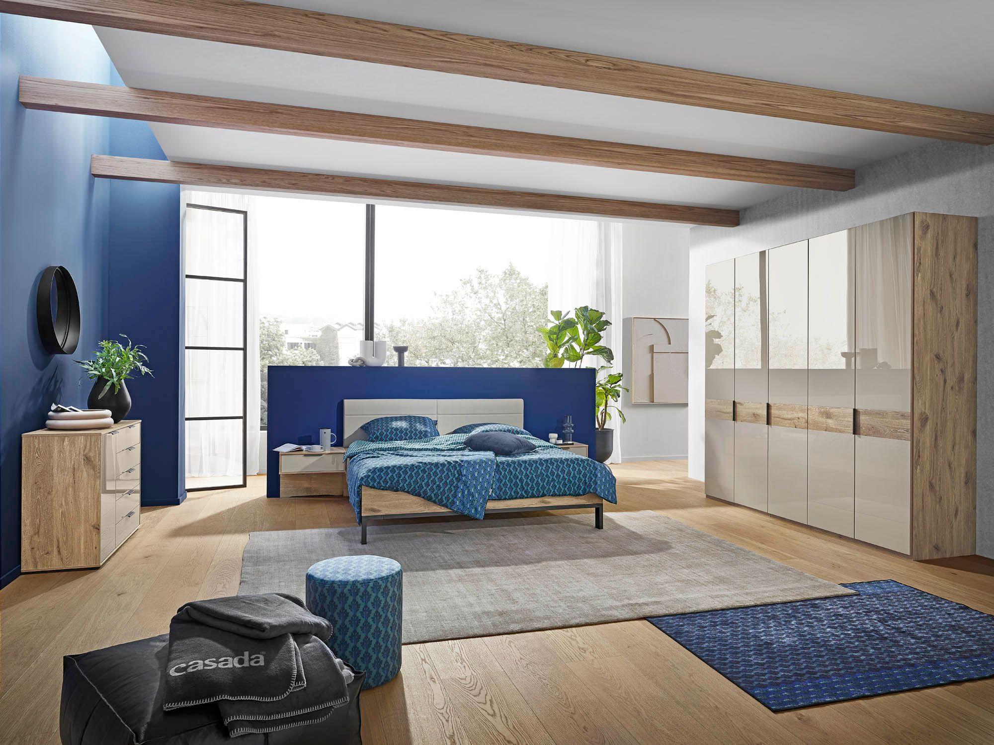 Drehtürenschrank 5türig, Korpus Nordic Eiche Nachbildung, Front Glas Kieselgrau, Bett mit Polsterkopfteil in Kunstleder, Liegefläche ca. 180 x 200 cm, 2 Nachtkonsolen mit schwebender Optik  