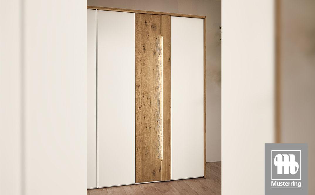 Kleiderschrank mit weißen Fronten und Holzelement.